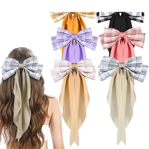 Plaid bow hair clip with long ribbons in multiple colors shown on model and flat lay