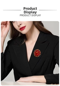 Detail of red crystal flower brooch with large gemstone on black blazer lapel