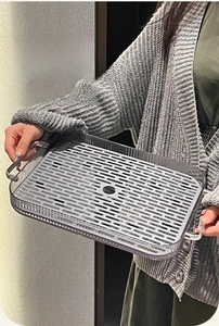 Macro view of a rectangular grey tray featuring silver handles and a drainage design