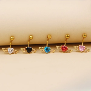 Cinq piercings de nombril cœur ailé en or avec pierres de zircon sur fond beige
