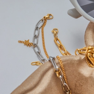 Detail of 18K gold and silver two-tone stainless steel bracelets with star charms