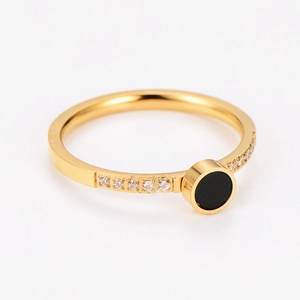Détail de la bague en acier doré avec insert noir et zircons sertis sur le bord latéral