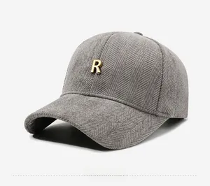 Detail of grey herringbone fabric baseball cap with a premium gold metal R logo