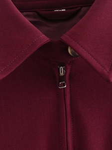 Detail of burgundy jacket neckline with metal zipper, buttons and size S label