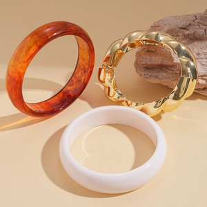 Three-piece bangle set with amber resin, gold twisted metal and white minimalist designs
