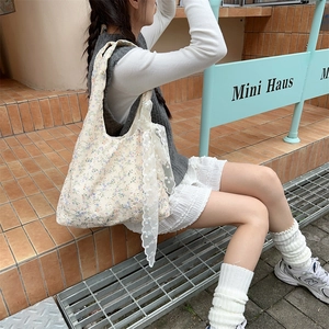Detail of floral canvas tote bag featuring white lace bow and vintage flower pattern
