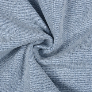 Dettaglio del tessuto denim lavato azzurro che mostra la morbida trama a saia