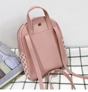 Close-up of pink mini backpack back pocket and geometric pattern detailing on the side