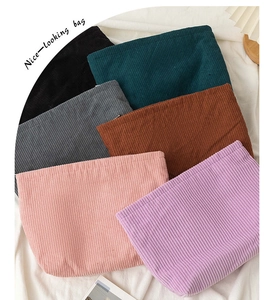 Close-up of stacked corduroy makeup bags in multiple colors with vertical stripe texture