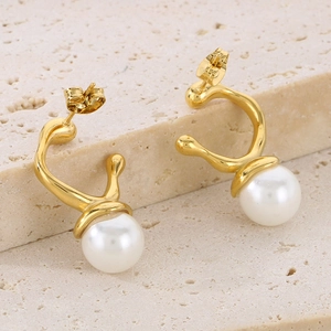 Detailed macro view of gold irregular metal frame with a large white pearl earring