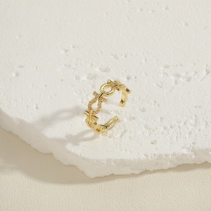 Detailed close-up of 18K gold-plated adjustable ring with cubic zirconia on white stone