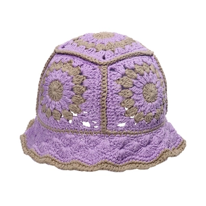 Detail of hand-crocheted sunflower bucket hat with purple and beige woven texture