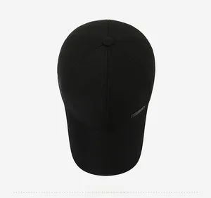 Detailed top view of a black twill baseball cap with a small metal plate logo decoration
