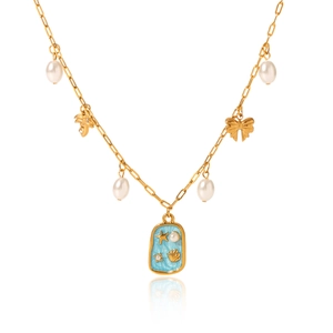 Golden ocean shell necklace with pearl tassels and blue enamel starfish charm on white surface