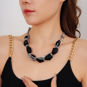 Detail view of multi-layered silver chain necklace with irregular black geometric beads