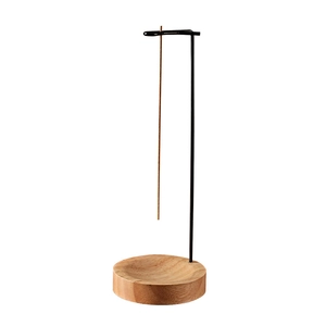 Creative hanging incense burner with wooden base and black metal stand on white background