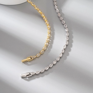 Detailed view of gold and silver tennis chains with pear-cut cubic zirconia stones