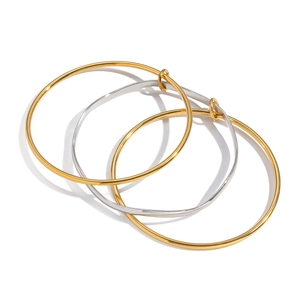 Detailed shot of three minimalist slim bangles in two gold and one silver polished finishes