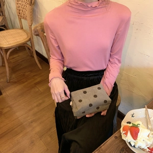 Pink corduroy makeup pouch shown in a cozy cafe setting for cosmetic storage