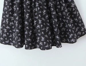 Detailed macro view of black floral fabric with purple prints and elegant draping
