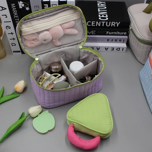 Detailed interior view of quilted purple cosmetic bag with mesh pocket and grid organizer