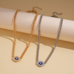 Macro detail of gold and silver evil eye necklaces with blue enamel and pavé crystals