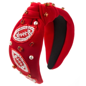 Macro detail of hand-sewn beads and rhinestones on luxury red rugby style knotted headband