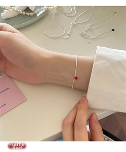 Dettaglio del bracciale in argento 925 con zircone a cuore rosso fiamma su catena sottile