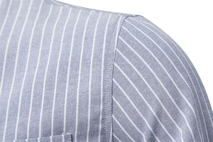 Detailed macro view of the shoulder seam and striped cotton fabric on a slim fit shirt