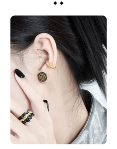 Detail shot of black and gold two-tone irregular grid studs and textured ear cuff