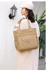 Détail du grand sac cabas en nylon kaki avec poches zippées multiples et poches latérales