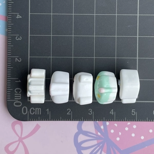 Mini resin castle house charms on a scale mat showing size for DIY crafts