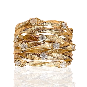 Golden multi-layer woven vine ring with sparkling zircons on white background