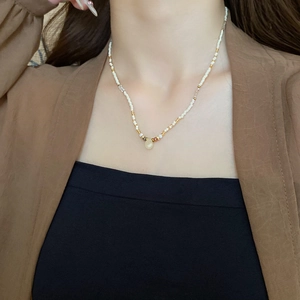 Detailed view of bohemian beaded necklace featuring a translucent teardrop pendant