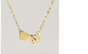 Détail du pendentif cœur en acier inoxydable 18K doré et lettre M sur une chaîne fine
