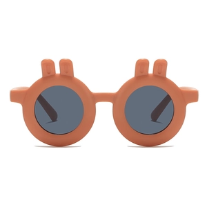 Orange toddler sunglasses with cute bunny ears and round dark lenses on white background
