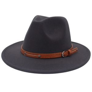 Close-up of a grey wool fedora hat featuring a brown leather belt with vintage metal studs