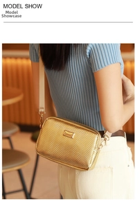 Detail of gold crossbody bag with V-shaped quilting and logo on a casual model show