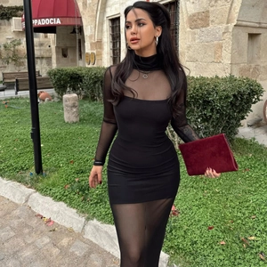 Détail de manches en maille noire transparente et robe patchwork moulante en extérieur