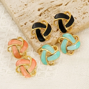 Golden knot earrings set with black green and orange enamel on a stone base