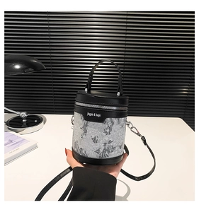 Close-up of black barrel handbag with Jingpin text, silver patterns and shoulder strap