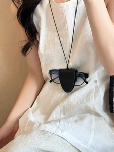 Detail of minimalist black leather glasses holder necklace with triangle fold design