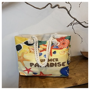 Canvas beach tote bag with summer paradise print and durable rope handles on wood surface