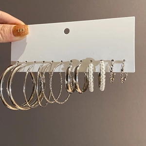 Set of six varied silver-colored hoop earrings including pearl and twisted designs