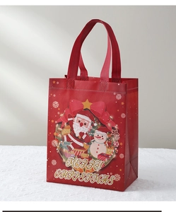 Detail view of red Christmas non-woven gift bag with festive Santa and snowman patterns