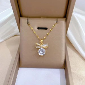Dettaglio collana fiocco dorato con zircone quadrato e cristallo in scatola portagioie