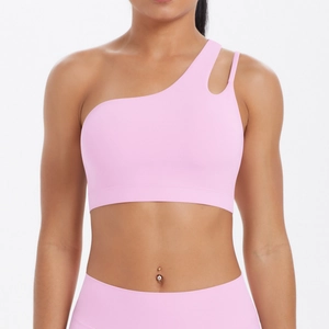 Detail of one-shoulder pink sports bra with unique cutout and asymmetrical strap design