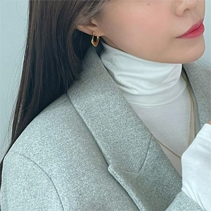 Minimalist gold irregular geometric earrings worn with professional business attire