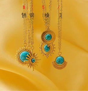Close-up detail of a vintage gold-plated stainless steel necklace with turquoise pendants