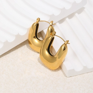 Close-up of polished 18K gold-plated U-shaped hoop earrings on a textured display stand